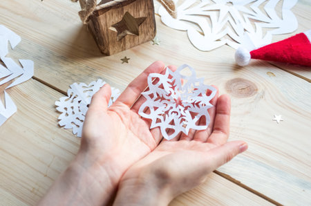 A snowflake made from paper with your own hands gracefully decorates a winter interior, adding warmth and a cozy atmosphere.の写真素材