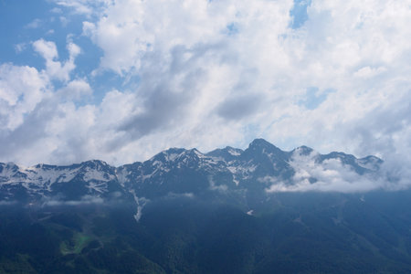 Epic mountain ranges twisting under the sun, with vibrant slopes and cloud shadows, embody the strength and beauty of nature.の写真素材
