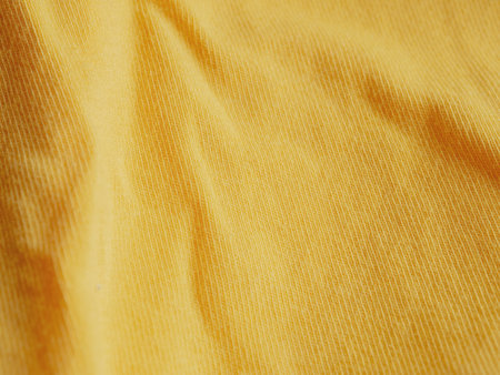 A close-up of bright yellow fabric with a textured pattern, adding brightness and liveliness, perfect for the design.の写真素材