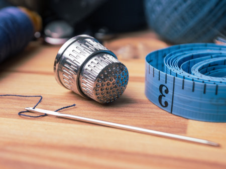 Close-up of a sewing needle and thimble. Detailed images of sewing tools highlighting their quality and functionality.の写真素材