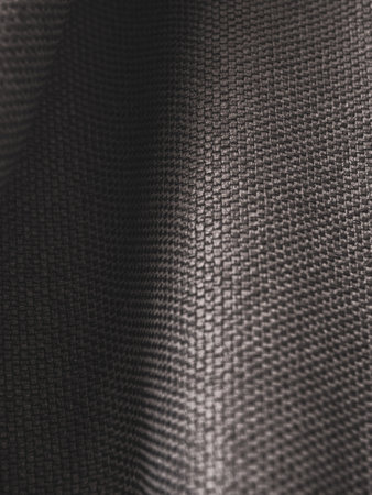 Macro photography of dark fabric, highlighting its texture and depth of color, creating an...
