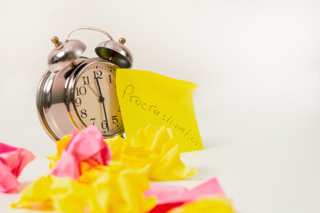 Procrastination: Close-up of an alarm clock and sticky notes, symbolizing procrastination and...