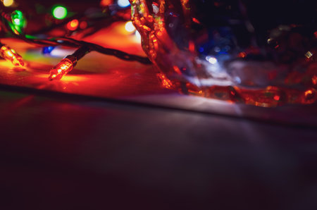 A New Year's garland with rich lights on a dark bokeh background creates a warm and mysterious atmosphere of a magical holiday.の写真素材