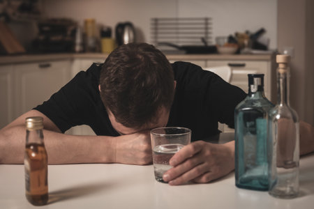 A man suffering from a hangover reflects his physical and emotional state.の写真素材