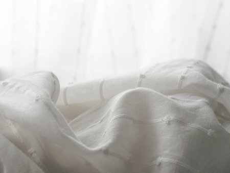 A close-up of a light translucent fabric that plays with the sun's rays, creating a feeling of lightness and airiness.の写真素材