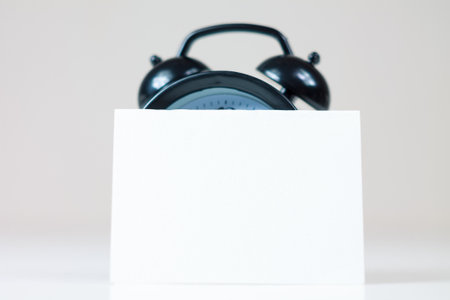 A blank reminder sticker and alarm clock inspire productivity, creating space for ideas and plans,...