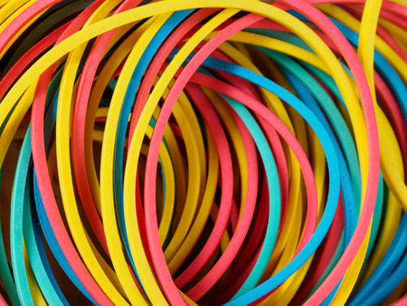 Bright close-up of elastic bands in different colors, perfect for illustrating ideas of organization and creativity.の写真素材