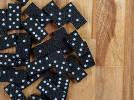 Dominoes arranged for a game. The tiles are black with white dots, creating a classic, pattern-rich image.の写真素材