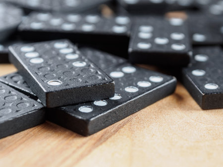 Dominoes arranged for a game. The tiles are black with white dots, creating a classic, pattern-rich image.の写真素材