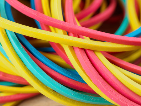 Bright close-up of elastic bands in different colors, perfect for illustrating ideas of organization and creativity.の写真素材