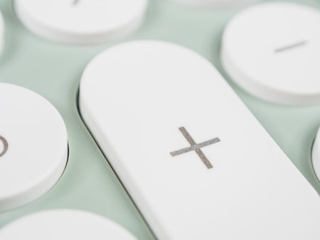 A plus (+) symbol on a calculator key, representing the addition operation.の写真素材