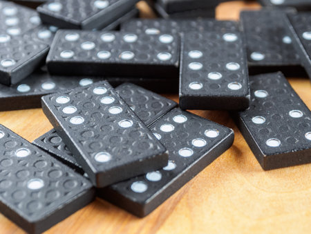 Dominoes arranged for a game. The tiles are black with white dots, creating a classic, pattern-rich image.の写真素材
