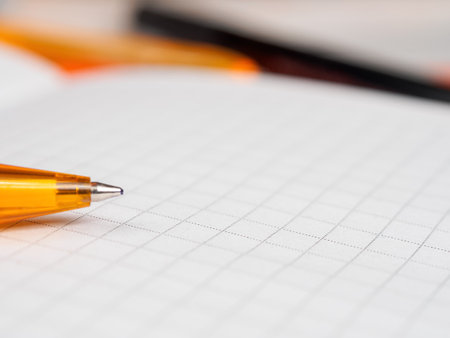 A close-up shot of a pen resting on a notepad, with ample free space in the background.の写真素材
