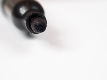 A close-up image of a marker positioned on a blank sheet of paper, with ample free space in the background.の写真素材