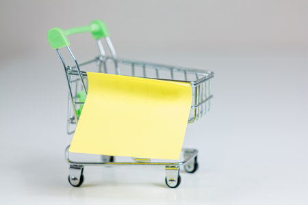 A blank sticker, ideal for adding inscriptions, placed on a shopping cart background, offering ample free copy space for promotional or informative messages.の写真素材