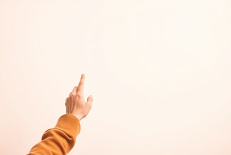 A person's hand and arm are shown in the act of pointing towards something unseen.の素材