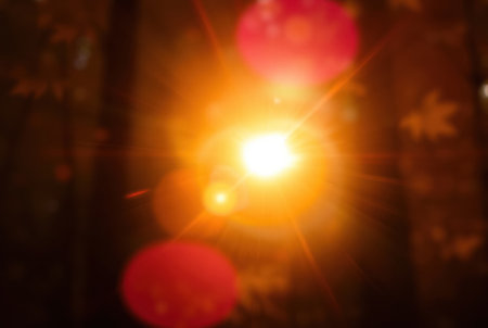 Bright lens flare with vibrant colors. Light streaks and balanced tones create a striking abstract background.の素材