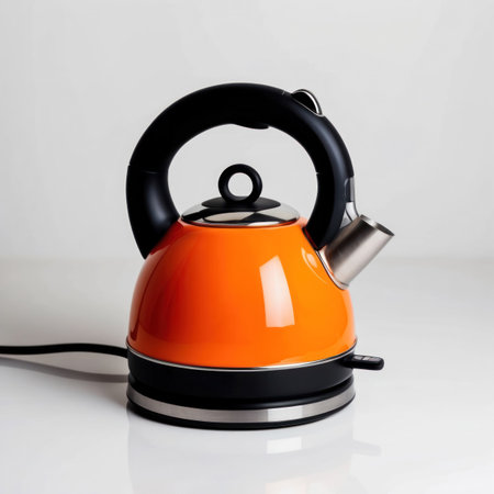 A vibrant orange electric kettle isolated on a clean background, perfect for kitchen or product design.の素材