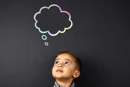 A young boy looks upwards with a thought bubble above him.の素材