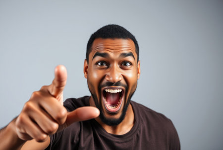 A black man with a surprised expression points directly at viewer.の素材