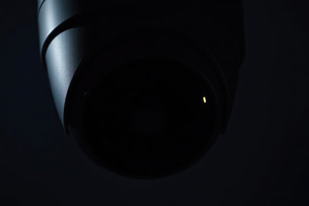 Low-angle shot of a security camera lens darkness observing intently.の素材