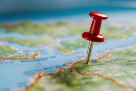 Location revealed. Close-up of a map marker with bokeh creating a sense of mystery and exploration.の素材