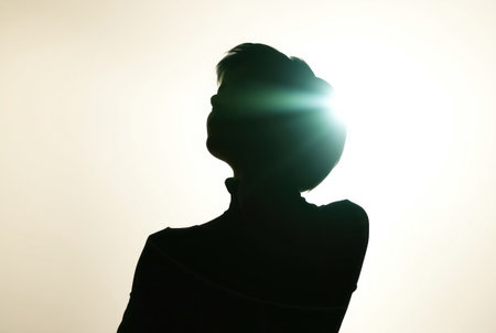 A solitary human figure stands in silhouette, lost in thought.の素材