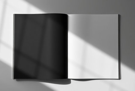 An open book with blank pages illuminated by sunlight and shadow.の素材