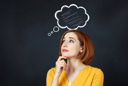 Thoughtful young woman with speech bubble above her head on dark backgroundの素材