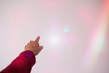 Woman hand pointing on white background with bokeh light effect.の素材