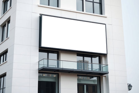 A contemporary buildings exterior featuring a large blank advertising sign.の素材