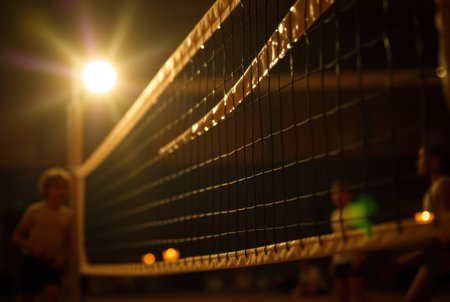 A dimly lit volleyball game taking place on a beach at night.の素材