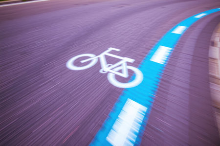 Blurred bicycle lane marking on a city street scene.の素材