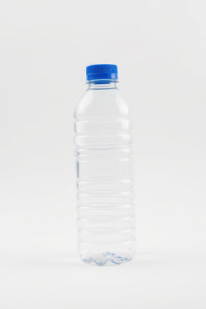 A single clear plastic bottle filled with water sits on a white surface.の素材