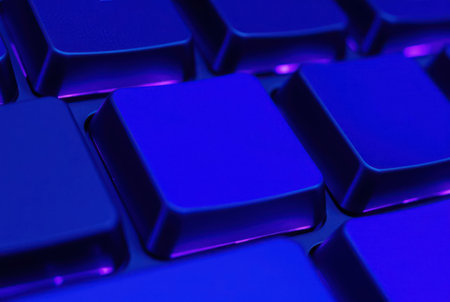 Close-up view of illuminated keyboard keys in vibrant blue light.の素材