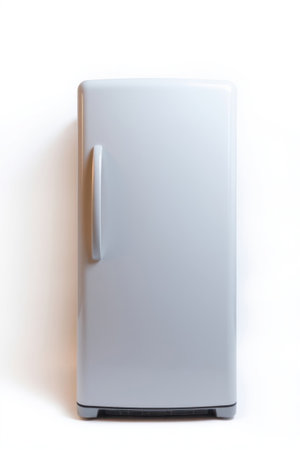 A clean white refrigerator stands alone on a bright surface.の素材