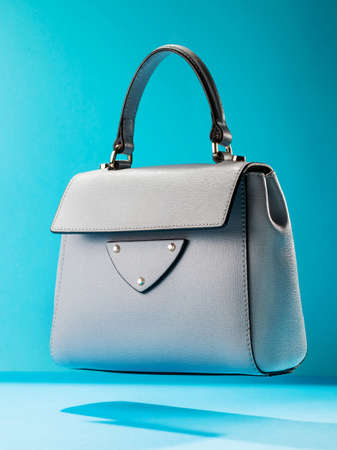 Stylish leather women's handbag on a blue background