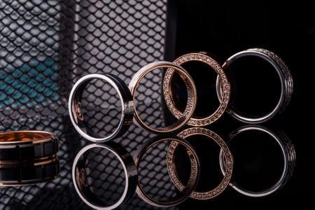 Band of engagement diamond engagement rings on dark fashion background with reflection, isolated, closeupの写真素材