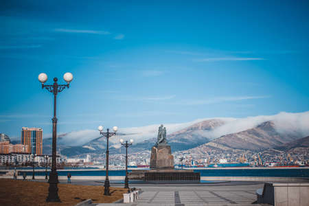 Embankment of the city against the background of snow-capped winter mountains