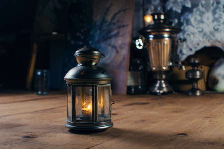Candlestick with burning candle on the wooden floorの写真素材