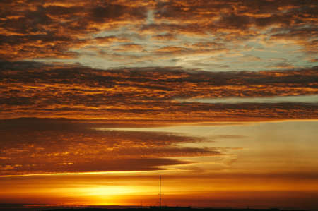 The sky at sunrise. Silhouettes of structures.の写真素材