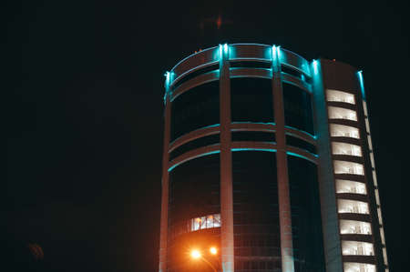 Modern house with blue light against a background of the night sky. Skyscraper. の写真素材