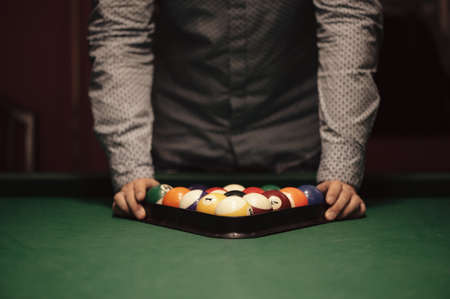American billiard poule. Triangle of billiard balls. A man getting ready to start a game of...