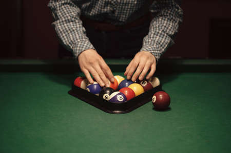 American billiard poule. Triangle of billiard balls. A man getting ready to start a game of billiards.の写真素材