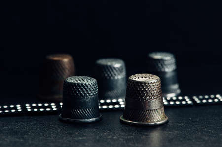 A few old thimbles on a black background. Brilliant bracelet.の写真素材