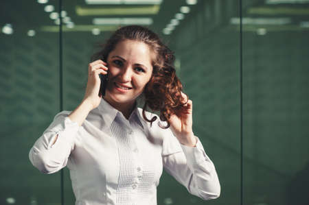 Business girl speaks on the phone in the office. Carrying out of consultations. Classic business.の写真素材
