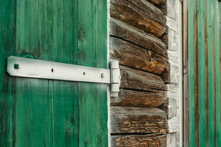 Painted white old iron hinges on the green gates to the garage.の写真素材