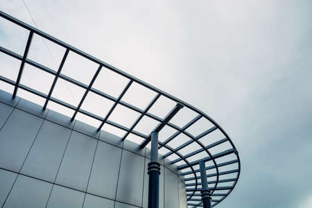 A rounded facade of a modern glass building against the sky.の写真素材