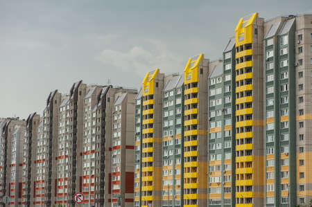 Modern multi-storey apartment buildings are built in a row. Multi-family houses of different colors.の写真素材