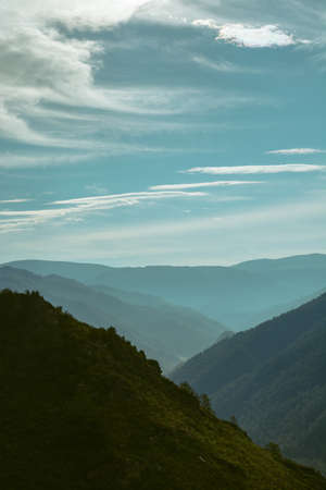A breathtaking landscape of the valley among the hilly mountains. Blue mountains in the distance. Russia, the Altai Mountains. Vertical image.の写真素材